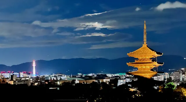 A lit pagoda and Kyoto Tower at night.